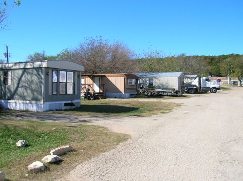 1996 Ford Bronco - A white semi-truck is parked in a lot with several mobile homes, on a sunny day.
