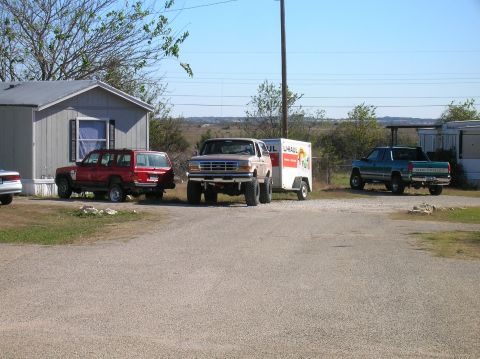 1996 Ford Bronco - Ford F-Series truck from the early 1990s is parked next to a U-Haul trailer.