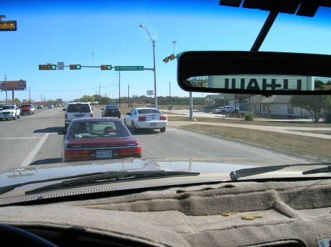 1996 Ford Bronco - Driving through an intersection on a clear day with several other vehicles present.
