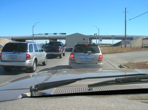 1996 Ford Bronco - Multiple vehicles are stopped in traffic on a sunny day, with an overpass in the background.