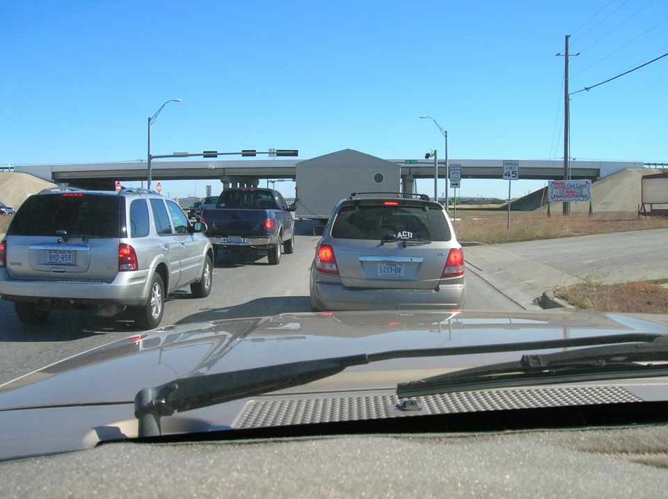 Silver SUV and blue pickup truck in traffic, seen from inside a vehicle