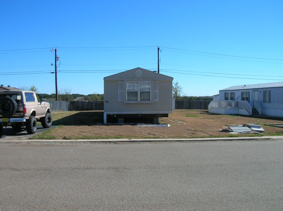 Tan Ford Bronco parked next to a mobile home