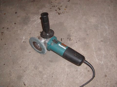 1991 Ford Bronco - A Makita angle grinder with a flap disc is shown on a concrete surface.
