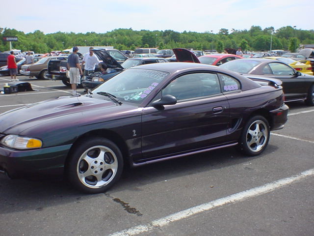 Purple 1994 Ford Mustang coupe with racing decals on windshield and side