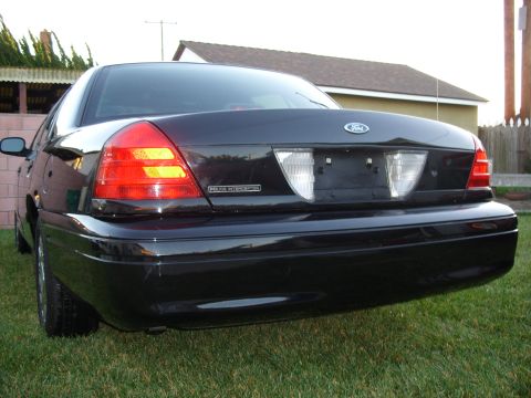 2005 Ford Crown Victoria - Rear view of a black 2005 Ford Crown Victoria Police Interceptor parked on grass.