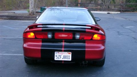 1996 Ford Probe - The car has a distinctive red and black stripe pattern on its rear end, with dual exhaust pipes visible.