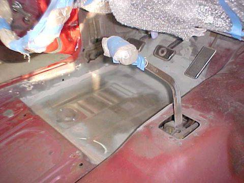 1967 Mercury Cougar - The interior floor of a vehicle is shown, with pedals and a gear shifter visible. Some areas are covered with protective wrap.