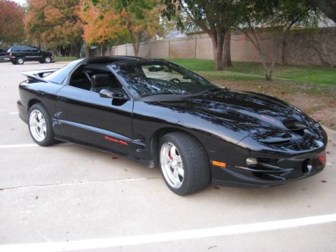 2002 Pontiac Trans Am - A black 2002 Pontiac Trans Am is parked in a lot, with another SUV in the background.