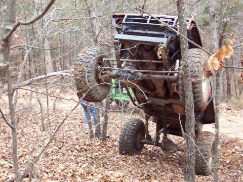1978 Ford Bronco - Off-road vehicle is stuck in trees after an apparent rollover incident.