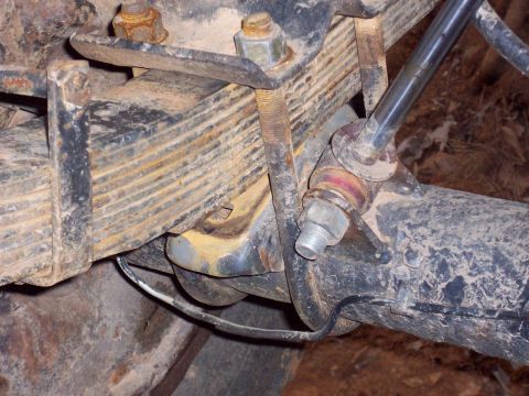 1978 Ford Bronco - This image shows a close-up view of a vehicle's rear suspension system, specifically the leaf springs and U-bolts.