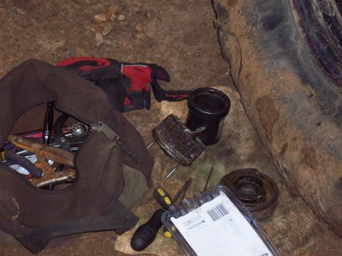 1978 Ford Bronco - Tools and a tire are laid out on the ground, possibly for a repair.
