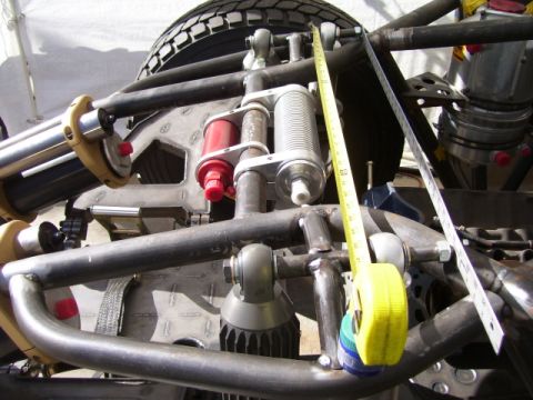 1968 Ford Mustang - Detailed view of custom suspension parts and a tire on a vehicle, with measuring tools present.