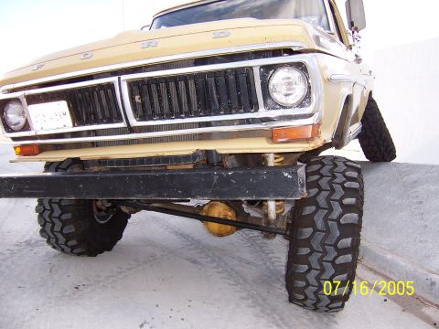 1994 Ford Bronco - Front view of a lifted Ford truck with aggressive off-road tires and a prominent grille.