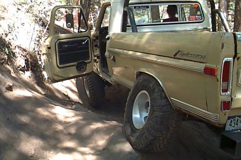 1994 Ford Bronco - This pickup truck, likely from the 1970s, is equipped with large off-road tires and appears to be navigating uneven terrain.