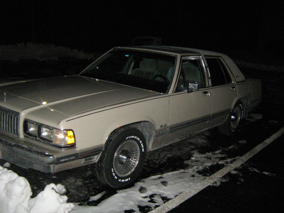 1988 Mercury Grand Marquis parked at night with snow on the ground. Firehawk Indy 500 tires are visible