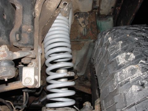 1979 Ford Bronco - Suspension spring and tire detail from an off-road vehicle.
