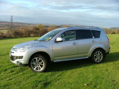 2007 Citroen C-Crosser - A silver 2007 Citroen C-Crosser is shown from the front three-quarter angle on a grassy field.