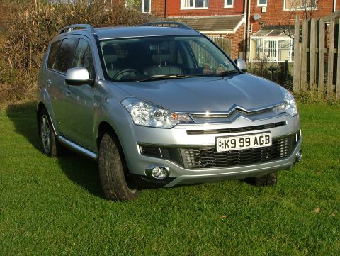 2007 Citroen C-Crosser - A silver 2007 Citroen C-Crosser is parked on a grassy lawn in front of a house.