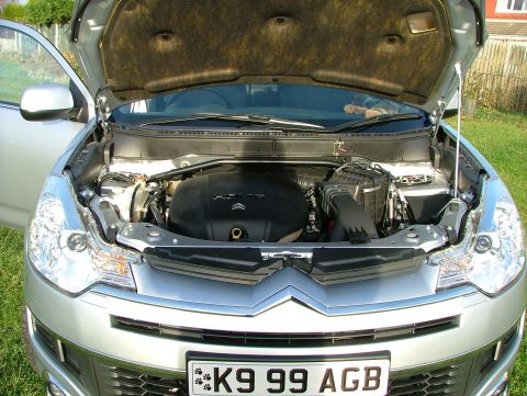 2007 Citroen C-Crosser - The engine bay of a silver car is visible with the hood raised. The license plate reads K9 99 AG.