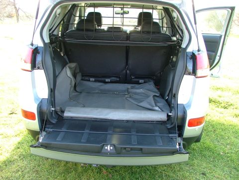 2007 Citroen C-Crosser - The cargo area of an SUV is shown with the tailgate open, revealing storage space and folded seats.