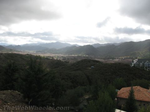 1968 Ford Mustang - A wide view of a valley surrounded by mountains under a cloudy sky, with residential buildings visible on a hillside.