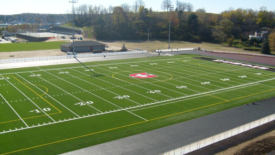 Football field with yard lines and a red logo in the center. "DUBOIS" is written on the track