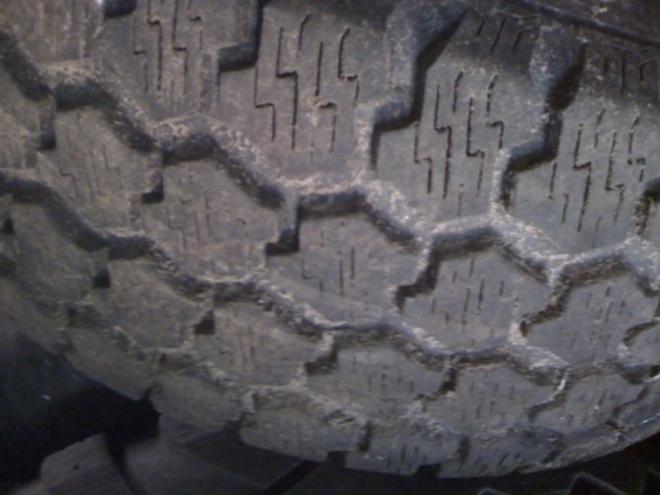 Extreme close-up of a worn all-terrain tire tread surface