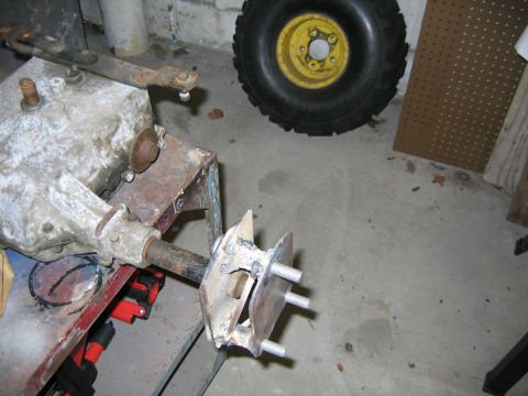 2001 Ford F-150 - A close-up view of a lawnmower's transmission and a detached wheel resting on a concrete floor.