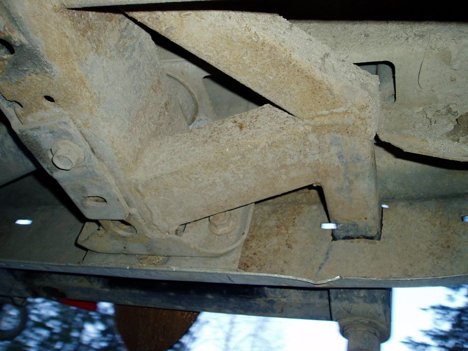 Underbody chassis components with rust and bolts visible