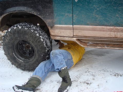 1996 Ford Bronco - Mechanic working on a 1996 Ford Bronco in snowy conditions.