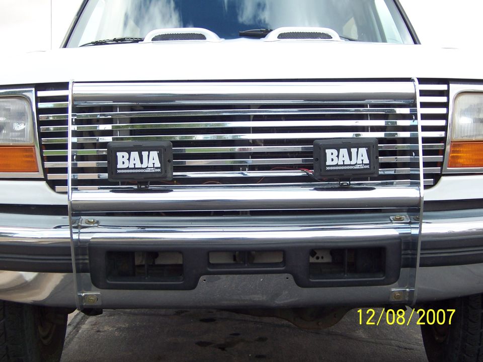 1996 Ford Bronco front grille with chrome bars and two Baja lights mounted on a brush guard