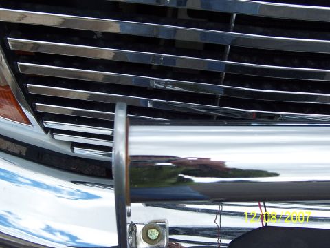 1996 Ford Bronco - Close-up of a vehicle's front grille and bumper guard, showing chrome details and reflections.