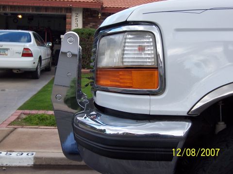 1996 Ford Bronco - Front view of a 1996 Ford Bronco with a chrome grille guard installed. Another car is parked in the background.