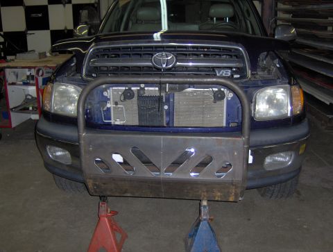 1978 Ford Bronco - A custom brush guard is installed on the front of a blue Toyota Tundra, which is elevated on jack stands.