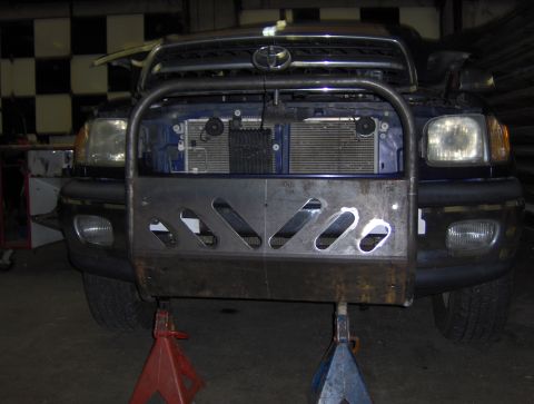 1978 Ford Bronco - Blue Toyota truck with a custom brush guard and bumper installed, supported by jack stands.