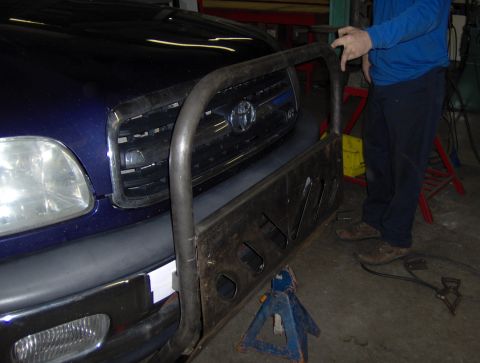 1978 Ford Bronco - A custom brush guard is being fitted to the front of a blue Toyota Tundra.