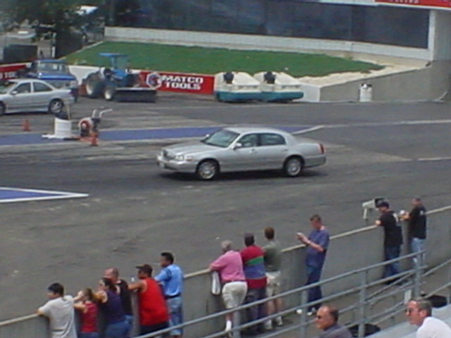 Silver 1994 Lincoln Town Car driving on a race track