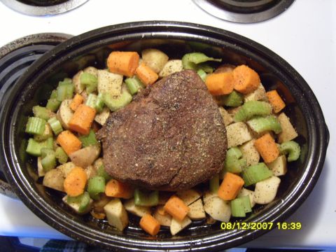 1989 Ford Bronco - A pot roast is surrounded by chopped potatoes, carrots, and celery in a black roasting pan.