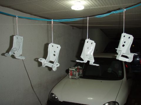 1995 Ford F-150 - Four newly painted door hinges are suspended for drying above a white car.