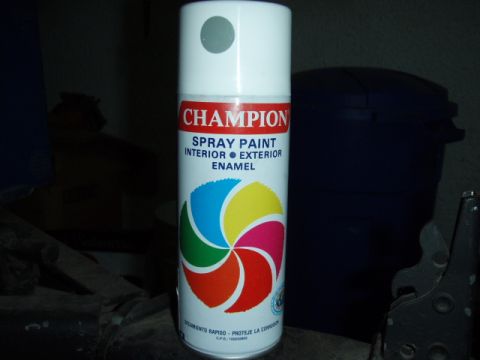1995 Ford F-150 - A white aerosol can of Champion interior/exterior enamel spray paint with a gray cap, photographed on a dark workbench with Spanish text re…