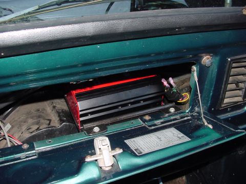 1979 Ford Bronco - An aftermarket amplifier is visible inside the glove compartment of a vehicle.