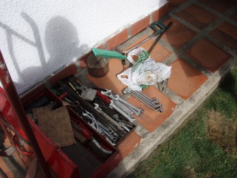 1995 Ford F-150 - A collection of tools, including a toolbox, wrenches, and a hacksaw, are laid out on a tiled patio.