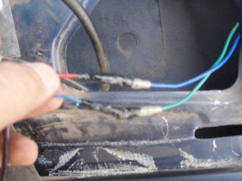 1995 Ford F-150 - Close-up view of a hand splicing wires as part of a vehicle repair.
