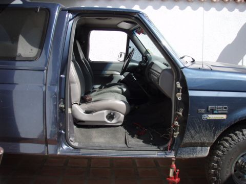1995 Ford F-150 - Interior view of a 1995 Ford F-150, highlighting the seats and dashboard with the driver's door open.