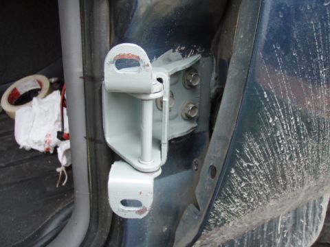 1995 Ford F-150 - Close-up of a repainted door hinge, with tape and rags visible in the background.