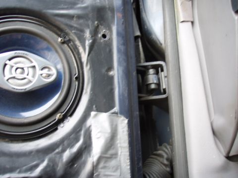 1995 Ford F-150 - A Pioneer speaker is visible inside a vehicle door panel, next to the door hinge mechanism.