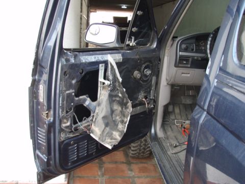 1995 Ford F-150 - The interior of a dark blue truck door is shown with the inner panel removed, revealing exposed wiring and components.