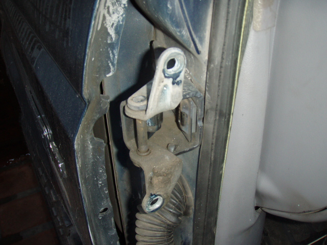 Exposed door latch, lock rods and wiring boot on a blue vehicle door jamb