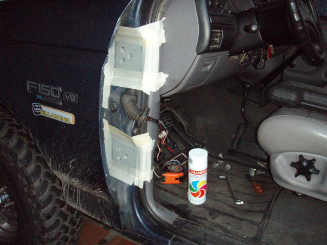Inside of a dark blue Ford F-150, door open, showing jamb with tape, wires, and spray can. F150 XL V8 badge visible
