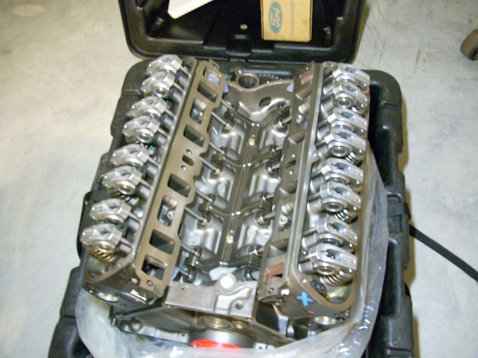 Ford V8 engine with valve covers removed, sitting in a black case